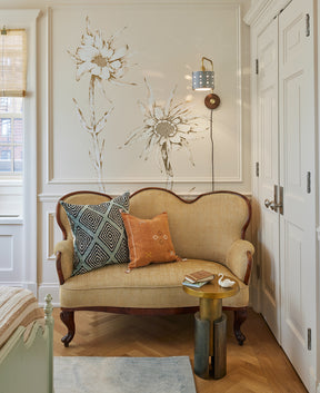 Articulating satin brass sconce with blue handstitched shade and walnut backplate in sitting room