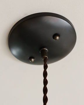 Black leather cone pendant with handstitched, perforated leather shade. Made by Lostine in Philadelphia. Hardwired or plug light fixture. Simple interior design, made in the USA.